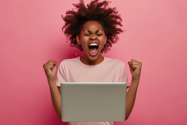 Photo une adolescente afro-américaine excitée et festive avec un ordinateur portable criant et le poing dans les mains vainqueur du concours