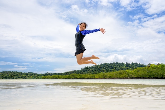 Une adolescente asiatique portant un maillot de bain s'amusant sur la plage pendant l'été en mer en Thaïlande