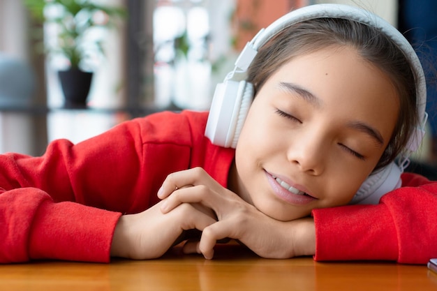 Adolescente aux yeux fermés écoutant de la musique via des écouteurs