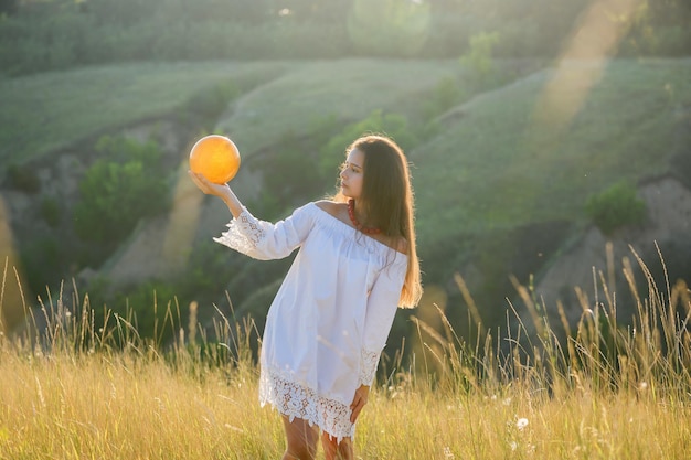 Adolescente avec un ballon de gymnastique sur le fond d'un ravin