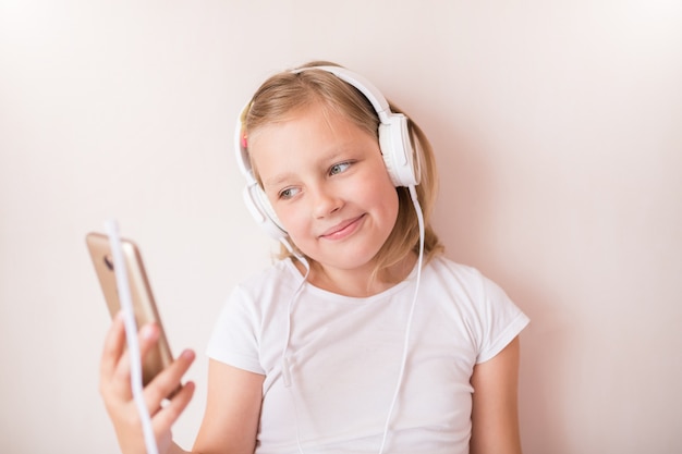 Adolescente blonde avec des écouteurs, écouter de la musique