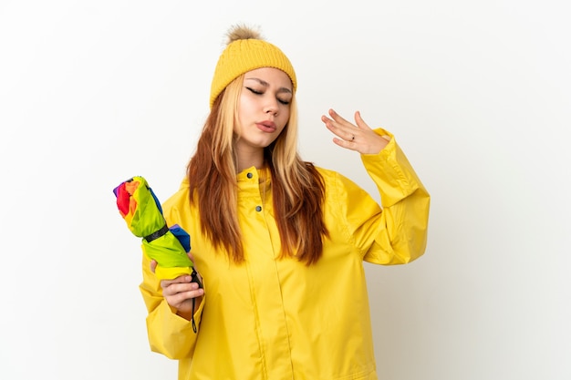 Adolescente blonde portant un manteau imperméable sur fond blanc isolé avec une expression fatiguée et malade