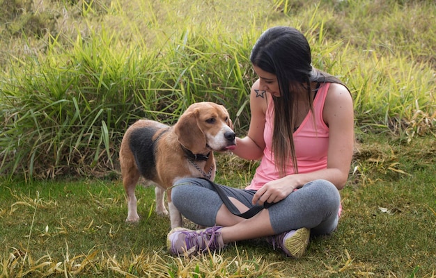 Adolescente brune avec un chien beagle dans le parc à l'extérieur