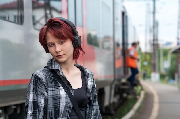 Adolescente avec un casque à la gare de train de banlieue