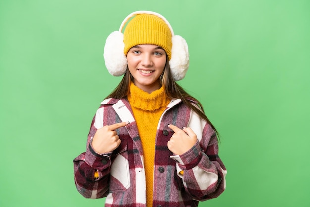 Adolescente caucasienne portant des manchons d'hiver sur fond isolé avec une expression faciale surprise