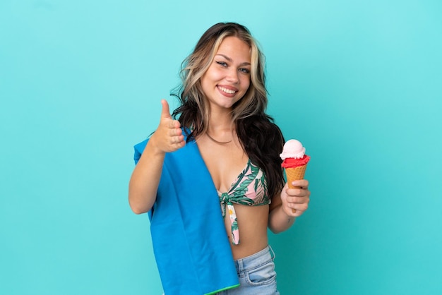 Adolescente caucasienne tenant une glace et une serviette isolée sur fond bleu se serrant la main pour conclure une bonne affaire