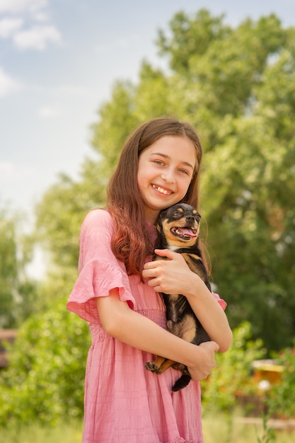 Une adolescente avec un chien Chihuahua dans ses bras