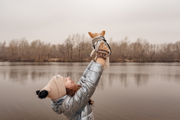 Adolescente et chihuahua. Fille dans une veste d'hiver sur une rivière avec un chien.