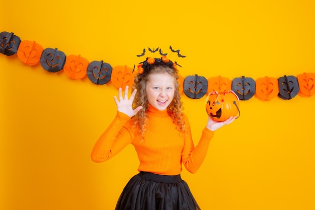 Adolescente en costume de sorcière sur fond jaune halloween