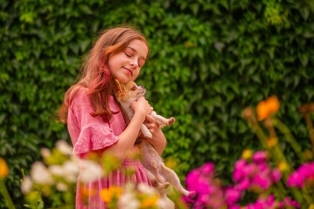 Adolescente dans une robe rose avec un chien Chihuahua à poil long blanc