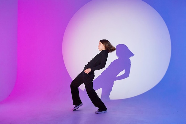 Une adolescente danse sous les projecteurs Le jeu d'ombre et de lumière