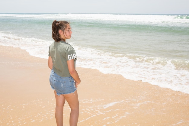 Adolescente déprimée sur la plage de sable