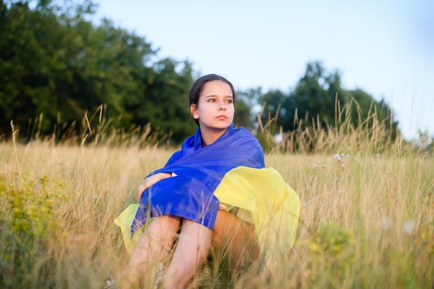 Une adolescente avec un drapeau ukrainien sur ses épaules