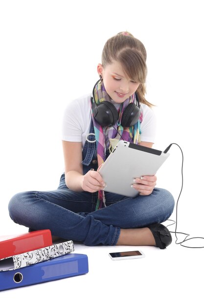 Adolescente écoutant de la musique avec tablet pc over white