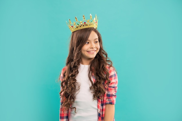 Une adolescente égoïste porte un diadème. arrogance et égoïsme. portrait de gloire. joyeux enfant porter une couronne. reine confiante. exprimer sa suffisance. princesse arrogante en diadème. enfant fier aux cheveux bouclés.