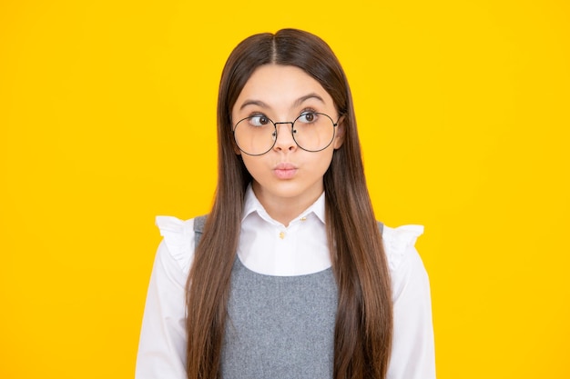 Adolescente enfant fille avec une expression faciale choquée Expression du visage surpris isolée sur fond jaune Drôle de surprise