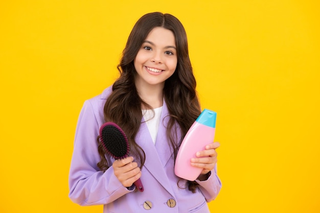 Adolescente enfant fille montrant des conditionneurs de shampoing en bouteille ou un gel douche produit cosmétique pour les cheveux bouteille