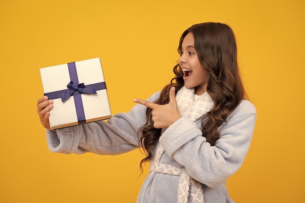 Une adolescente étonnée, un enfant avec une boîte à cadeaux, une adolescente donnant un cadeau d'anniversaire, un cadeau de salut et