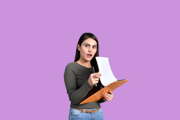 Adolescente étudiante heureuse tenant une planche à pince et un stylo modèle pakistanais indien