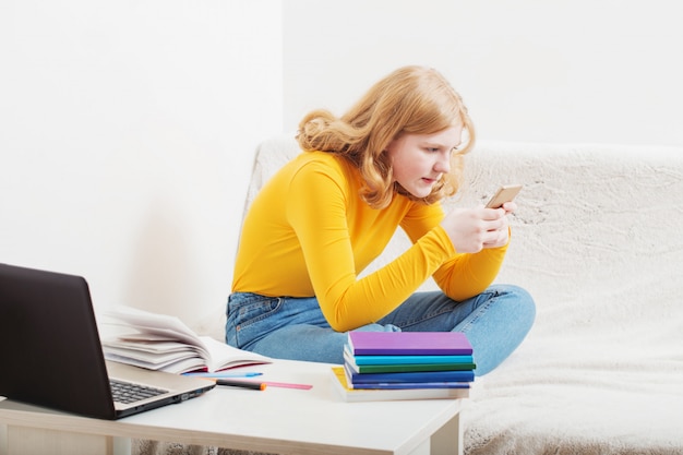 Adolescente étudie et apprend avec ordinateur portable à la maison.