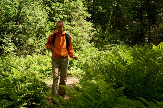 Adolescente à l'extérieur dans un parc forestier parmi les fougères