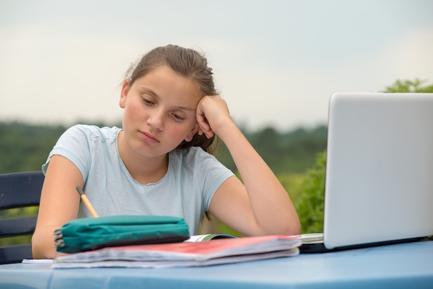 Adolescente fait ses devoirs dans le jardin