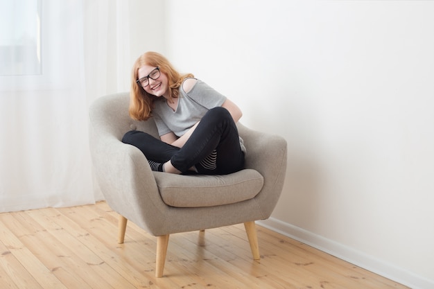 Adolescente en fauteuil gris