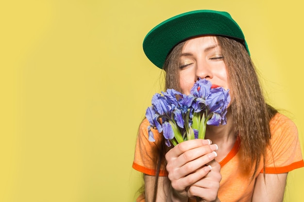 Adolescente avec des fleurs sur fond jaune