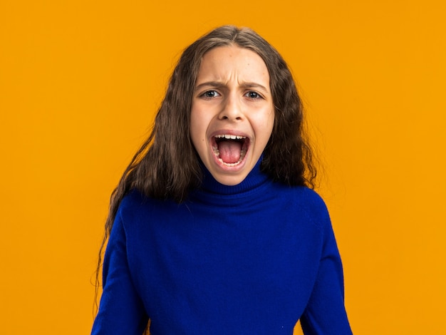 Adolescente furieuse criant d'isolement sur le mur orange