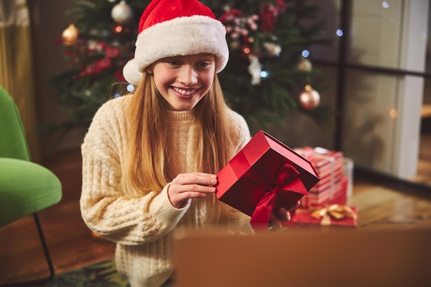 Adolescente gaie tenant le présent à Noël