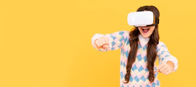 Une adolescente heureuse porte des lunettes VR sans fil à l'aide d'un casque VR kid jouer au jeu vidéo Avenir numérique Bannière d'enfant fille avec réalité virtuelle vr casque studio portrait with copy space