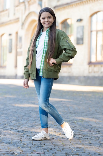 Adolescente heureuse posant dans un style décontracté à la mode en plein air