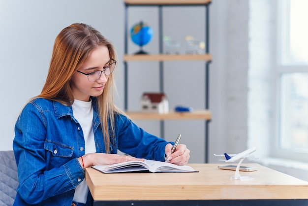 Adolescente joyeuse à des études de vêtements en denim à la maison.