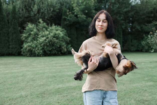 Adolescente lors d'une promenade dans le parc d'été avec son animal de compagnie Yorkshire terrier Enfant promenant un chien