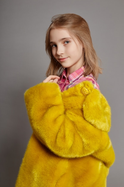 Adolescente en manteau de fausse fourrure jaune, portrait