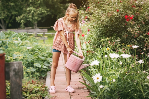 Adolescente mignonne arrosant les fleurs