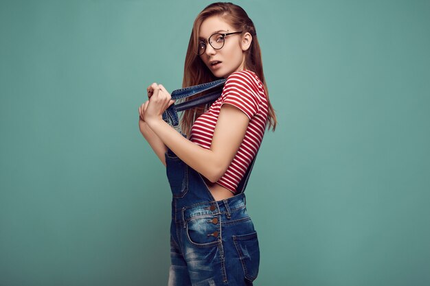 Adolescente mignonne en salopette en jean et lunettes