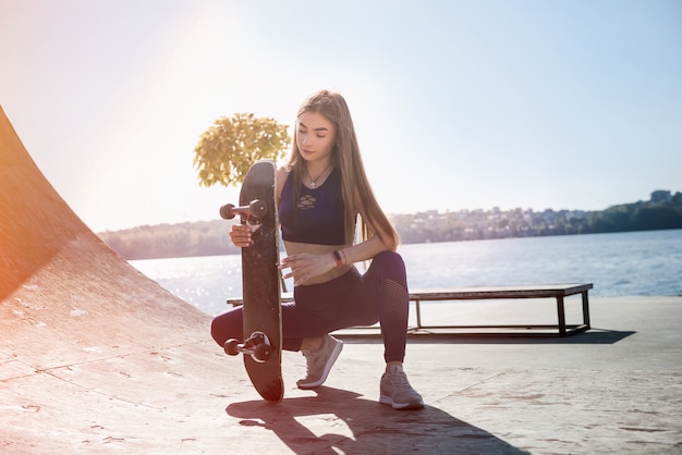 Une adolescente monte sa planche à roulettes. Mode de vie sain