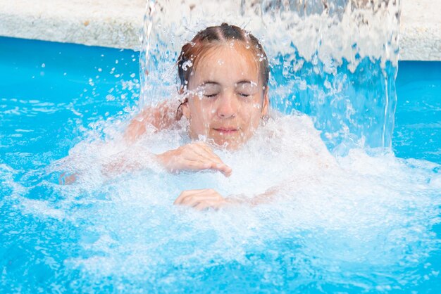 Une adolescente nage dans une piscine à l'eau bleue