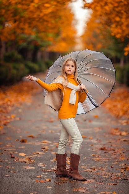 Photo une adolescente avec un parapluie transparent dans les mains lors d'une promenade en automne dans une rue de la ville