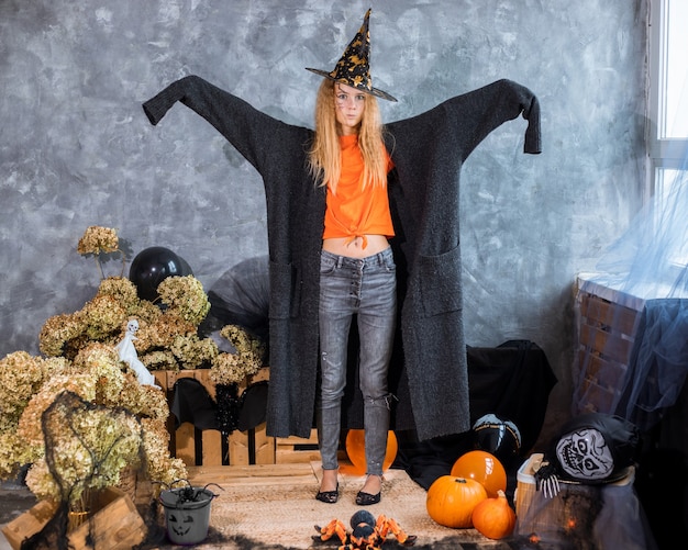 Adolescente parmi le décor pour les vacances d'Halloween, en énorme veste en rôle de fantôme