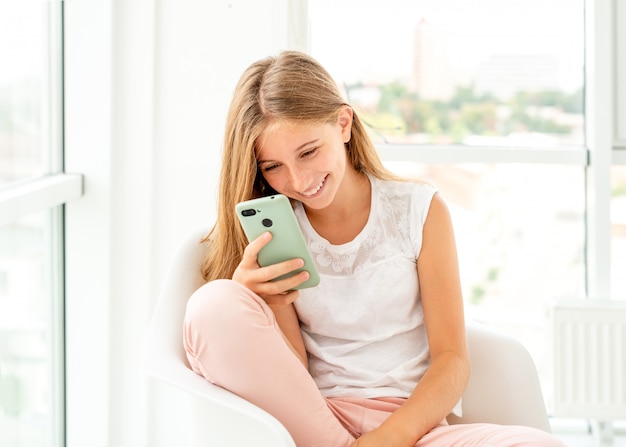 Adolescente, passer des loisirs avec son téléphone à l'intérieur