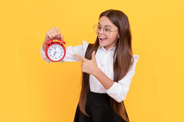 Adolescente ponctuelle vérifiant l'heure heureux nerd enfant pointant le doigt sur le réveil