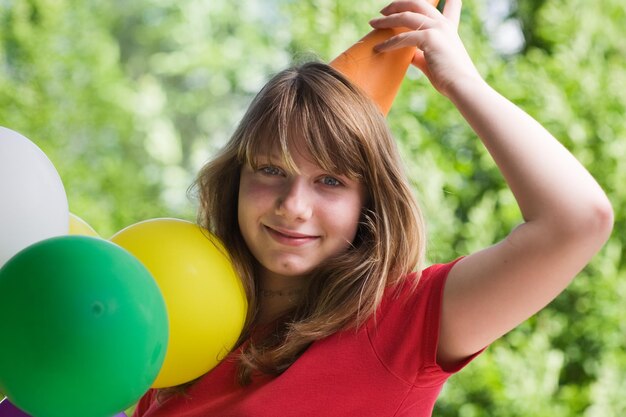 adolescente, porter, chapeau fête, tenue, ballons, portrait