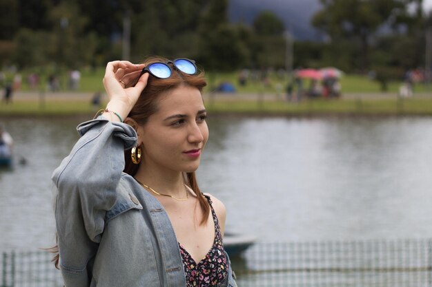 Une adolescente près du lac médite, se détend et sourit dans le parc Simon Bolivar à Bogota, en Colombie. Inspiration, nature, beauté, harmonie, paysage en plein air.