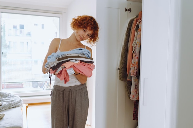 Une adolescente qui regarde des vêtements dans sa garde-robe.