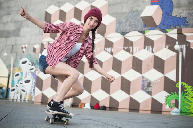 Adolescente s'amusant le soir d'été à l'extérieur. Elle fait du skate