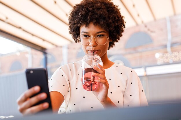 Photo une adolescente se fait un selfie en buvant dans un café.
