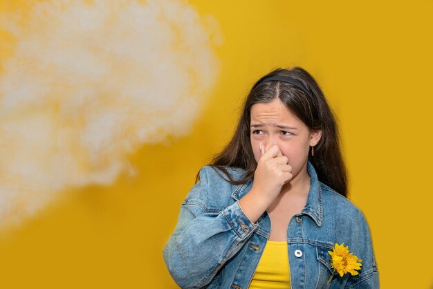 Une adolescente se pince le nez à cause des vapeurs toxiques de la voiture, de la mauvaise odeur, de la pollution de l'air, des allergies à la poussière