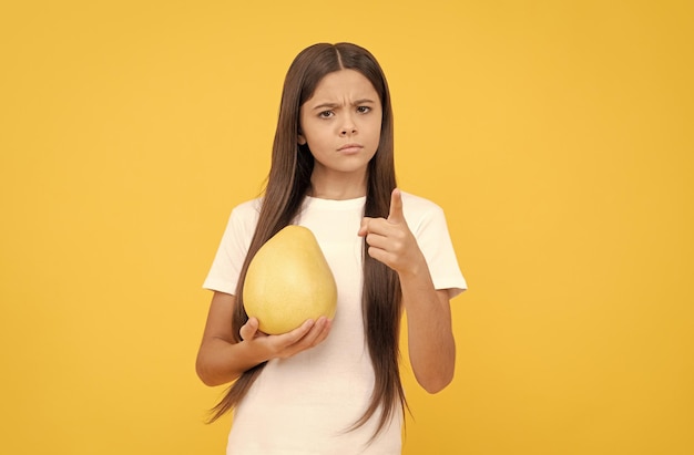 Adolescente sérieuse avec de la vitamine pomelo et suivre un régime des aliments sains manger la santé de l'enfance gros agrumes exotiques naturels biologiques mûrs pomelo frais vie saine régime de fruits